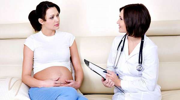 Беременная девушка разговаривает с врачом