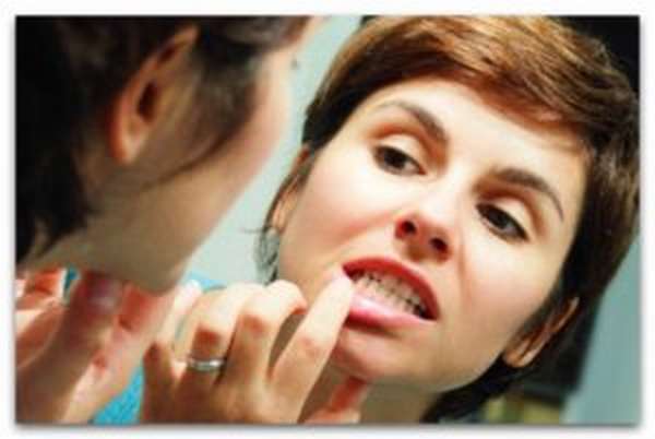 девушка у зеркала проверяет зубную полость