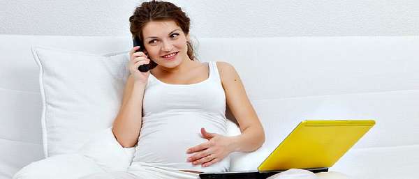 Беременная девушка разговаривает по телефону